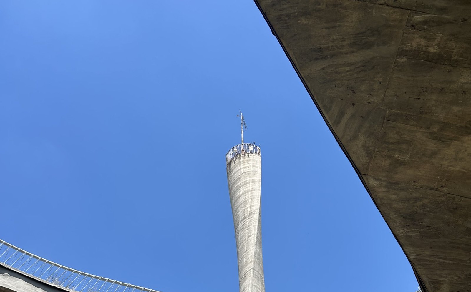 El Faro del Bicentenario visto desde abajo, enmarcado por una pasarela curva de hormigón del Centro Cultural Córdoba